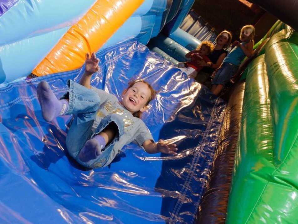 Child on bouncy castle slide | © Sportzentrum Grächen